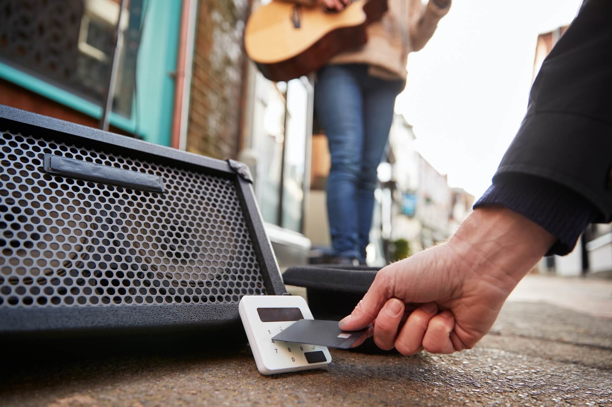 Close Up Of Person Using Contactless Payment Machine At Feet Of Female Musician Busking In Street