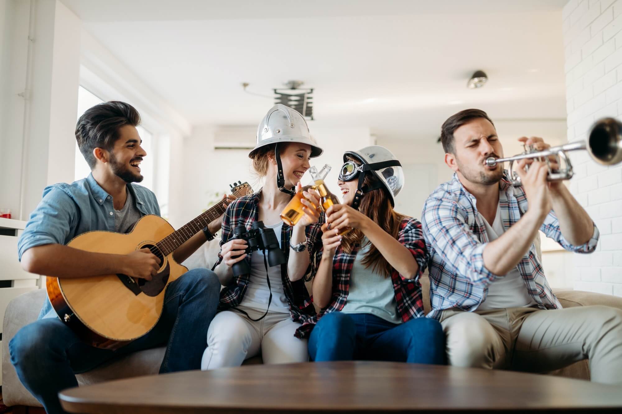 Group of friends playing guitar and partying at home